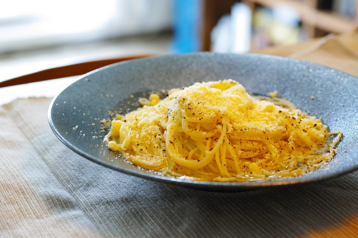 チーズをかけたパスタを盛った皿