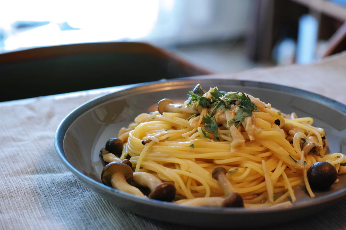 きのこを添えたパスタを盛った皿