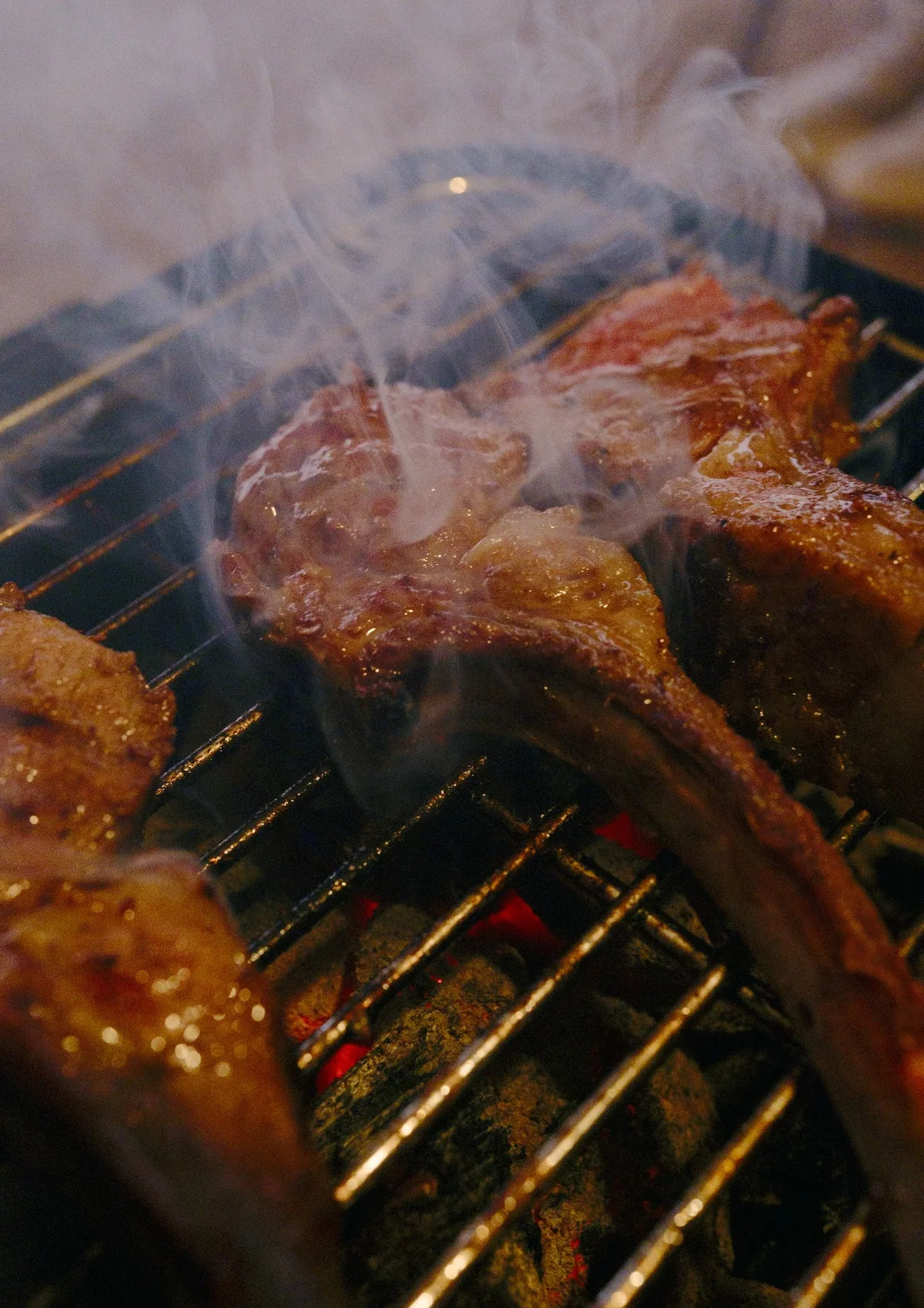 煙が立ち上る網の上で肉を焼いている