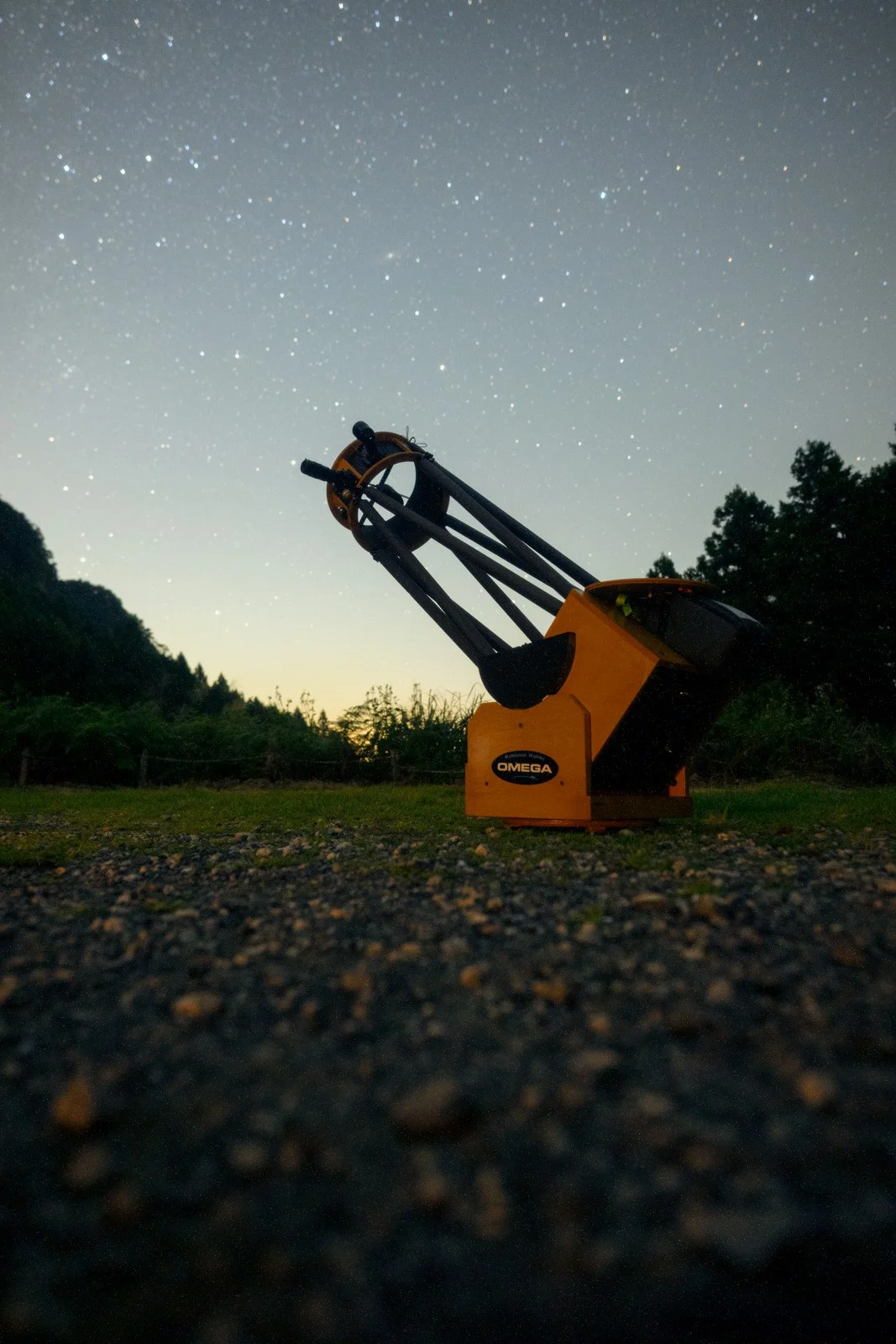 星空の下、草地に据えられた木製のOMEGA望遠鏡