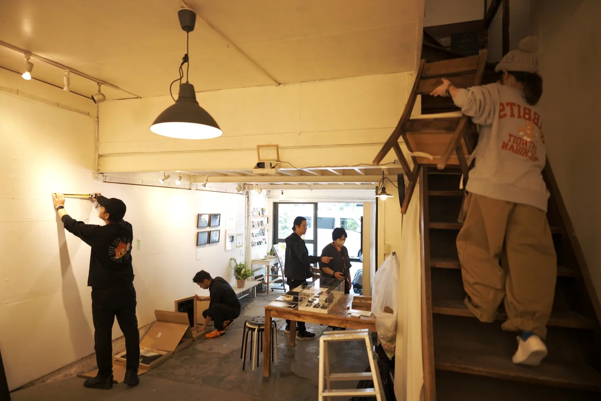 展示会場で壁を測ったり、作品を準備したりする仲間たち